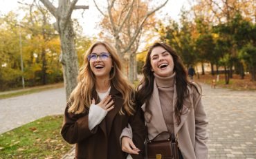 Cheery optimistic young women friends walking