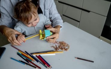 Mom and baby sharpen colored pencils