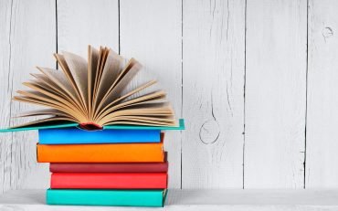 The open book on other multi-coloured books.